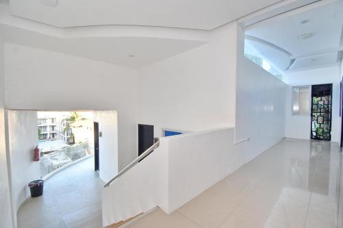 长滩岛Blue Suites Boracay的开放式走廊设有白色墙壁和白色瓷砖地板。