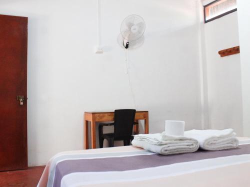 YurimaguasCasa Albina的客房配有带毛巾的床和风扇。