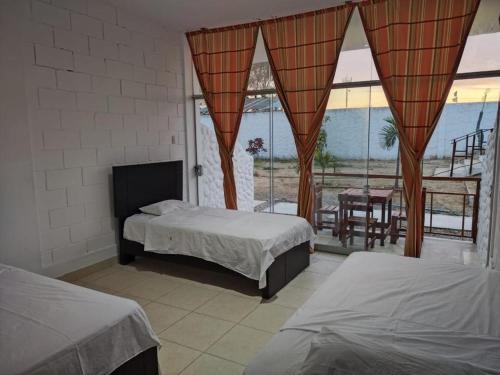 索里托斯Bamboleo Club Zorritos的一间带两张床的卧室和一个带桌子的阳台