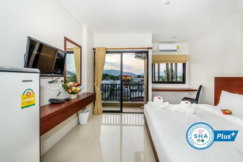 普吉镇The Topaz Residence Phuket Town的一间酒店客房,设有两张床和电视