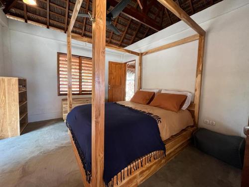 内布拉拉VILLA LANGIT TEDUH ROTE的一间卧室配有一张四柱床。