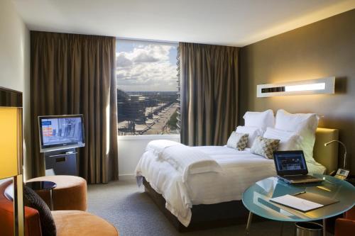 悉尼铂尔曼悉尼奥林匹克公园酒店的酒店客房设有一张床和一个大窗户