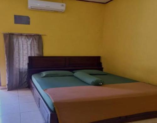 贝努阿亚尔Hotel prima的黄色间内一间卧室,配有一张床