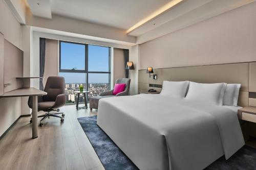 顺义北京临空皇冠假日酒店的酒店客房设有一张白色大床和一张书桌