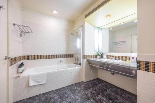 奥克兰Charming Studio Apartment in Auckland Central的带浴缸、水槽和镜子的浴室