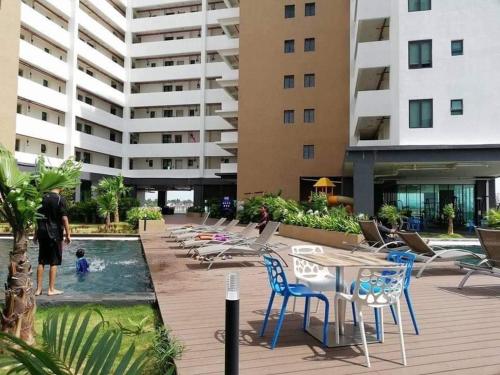 波德申码头酒店及服务式公寓的站在建筑物旁边的游泳池里的人