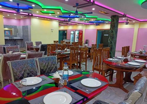 曼达莫尼ST Apple Beach Resort Mandarmani的用餐室配有桌椅和灯光