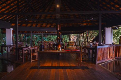 刁曼岛Japamala Resort by Samadhi - Adults Only的一间铺有木地板的餐厅,配有桌椅