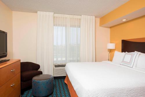 布卢明顿Fairfield Inn & Suites by Marriott Bloomington的酒店客房设有一张大床和一台电视。