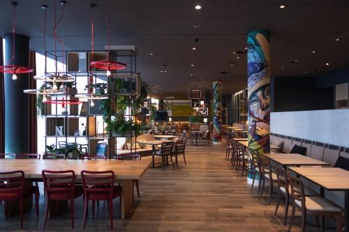 霍夫多普IntercityHotel Amsterdam Airport的用餐室配有木桌和椅子
