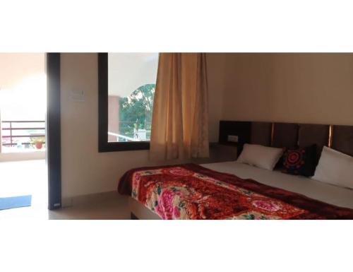 奥拉奇哈Mridul Homestay Orchha, Madhya Pradesh的一间卧室设有一张大床和大窗户