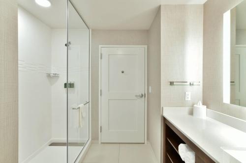欧克莱尔Residence Inn by Marriott Eau Claire的一间带玻璃淋浴和水槽的浴室