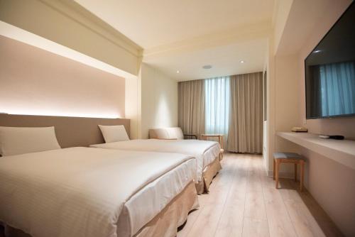 台南台南大饭店的酒店客房设有两张床和电视。