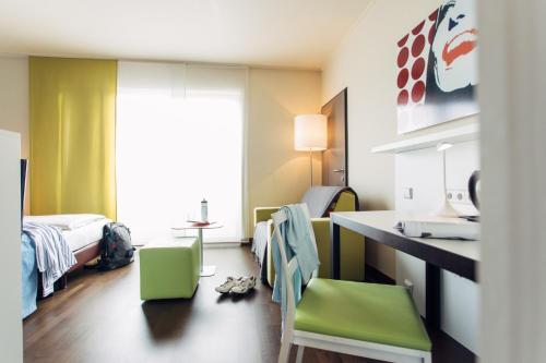 格拉茨harry's home hotel & apartments的客房设有带一张床和一张书桌的卧室。