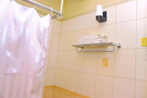 内罗毕Jamia Central Hotel的浴室提供白色毛巾和毛巾架