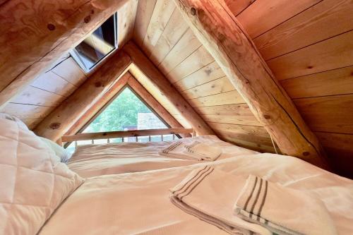 San CarloRustico Savinera - Happy Rentals的木制阁楼上的一张床位,设有窗户