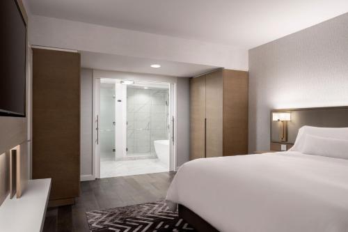 安纳海姆The Westin Anaheim Resort的一间卧室配有一张床,浴室设有浴缸