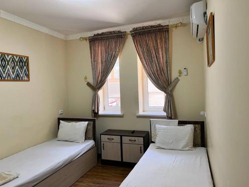 布哈拉Ikat Terrace的带2扇窗户的客房内的2张床