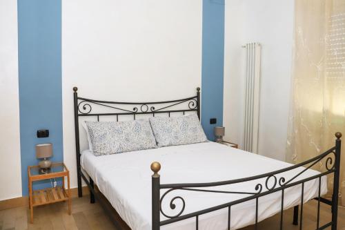 那不勒斯La Casa di Partenope by Wonderful Italy的一间卧室设有黑色和白色的床和蓝色的墙壁。