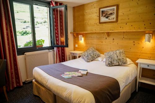 Villar-dʼArène法拉池酒店的卧室配有一张床铺,位于带木墙的房间内