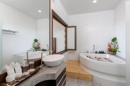 卡伦海滩Secret Cliff Resort & Restaurant - SHA Plus的浴室配有大型白色浴缸、盥洗盆和浴缸。