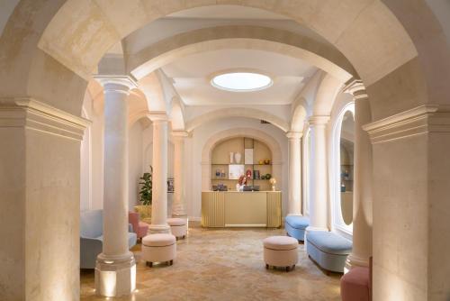锡拉库扎Palazzo Artemide - VRetreats的大房间设有白色的柱子和蓝色的椅子