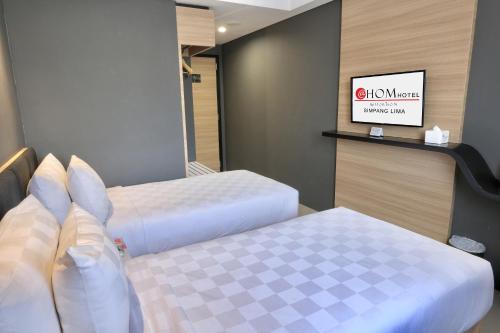三宝垄三宝垄霍姆@斯姆邦利玛酒店的酒店客房,设有两张床和镜子
