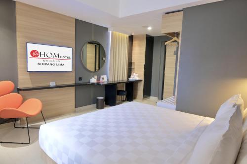 三宝垄三宝垄霍姆@斯姆邦利玛酒店的酒店客房,配有床和镜子