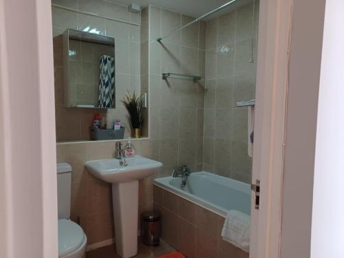 邓斯特布尔Huku Kwetu -The Maltings White Door-1st Floor-2 Bedroom Apartment -Self Catering-Quiet- Free Parking的一间带水槽、浴缸和卫生间的浴室