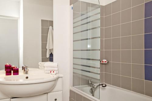 马诺斯克Apparthotel Séjours & Affaires Manosque的一间带水槽和淋浴的浴室