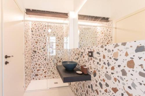 里米尼Luxury & Design: Oasi nel centro storico di Rimini的带淋浴的浴室,在柜台上设有碗