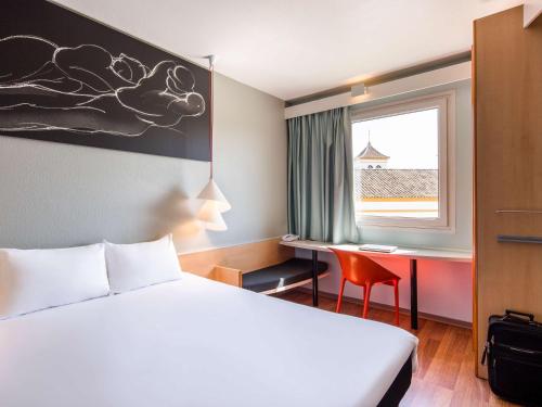 塞维利亚宜必思塞维利亚酒店的配有一张床、一张书桌和一扇窗户的酒店客房