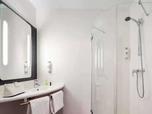 塞维利亚宜必思塞维利亚酒店的白色的浴室设有水槽和淋浴。