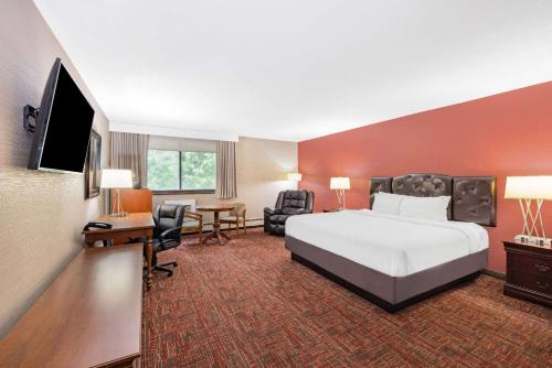 格兰福克大福克斯华美达酒店的配有一张床和一台平面电视的酒店客房