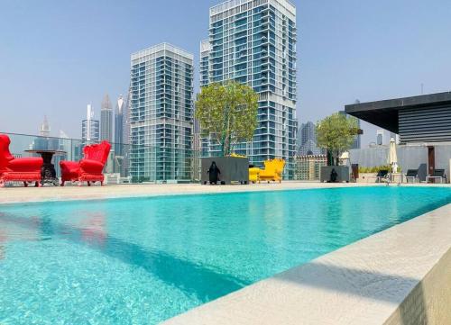迪拜Fully Furnished 3BR+ Maid’s in the heart of Dubai的城市里一个带桌椅的大型游泳池
