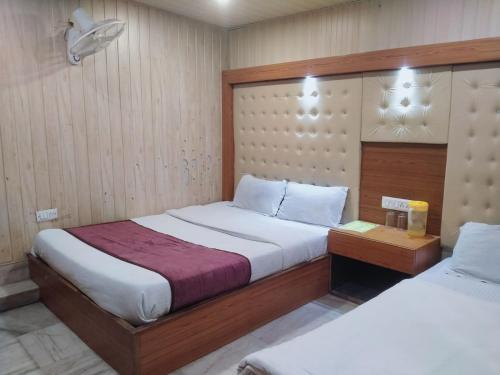 奈尼塔尔Hotel Flatties Mall Road Nainital-Near Lake View point的一间卧室配有两张床、床头柜和四柱床。