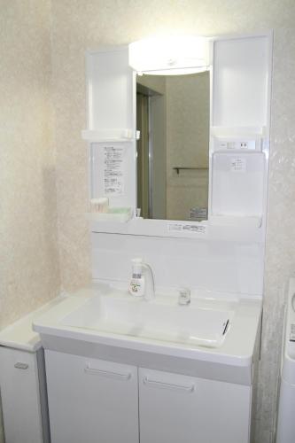 神户Private Inn Bambee的浴室设有白色水槽和镜子