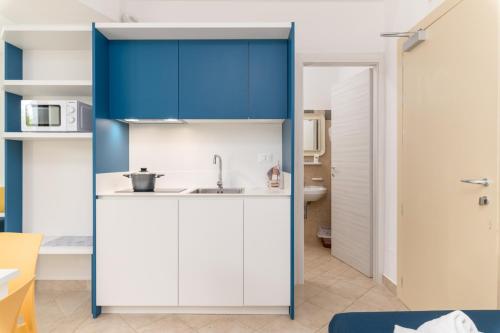 托雷桑塔萨宾娜Calanca Apulian Residence的厨房配有蓝色橱柜和水槽