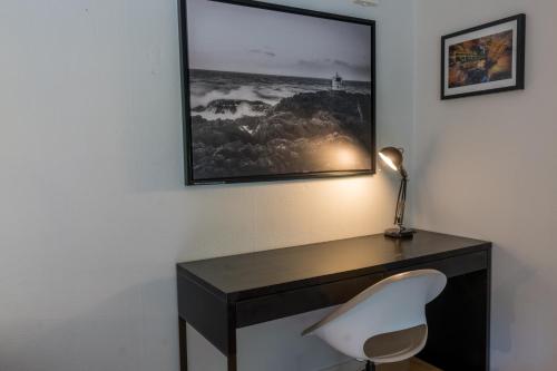 FarhultNorra Häljaröd的一张带白色椅子的桌子和墙上的照片