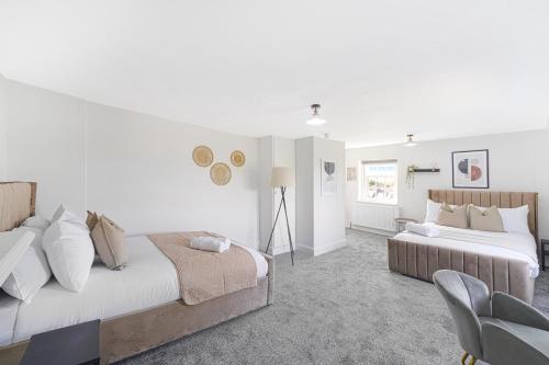 伦敦LiveStay - London Chiswick Apartments with Free Parking的一间卧室配有两张床和椅子