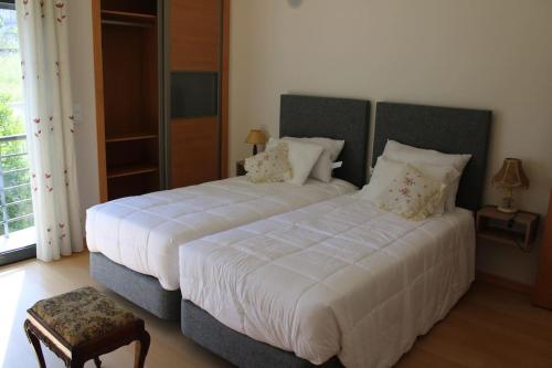 法蒂玛Charming Religious House II的一间卧室配有两张带白色床单和枕头的床。