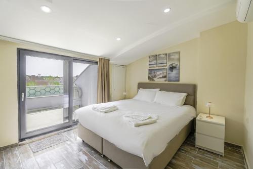 贝莱克Flat w Shared Pool and Balcony 8 min to Beach的一间卧室设有一张大床和一个大窗户