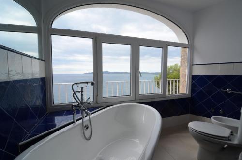埃斯塔蒂特Villa Narcol的带浴缸和卫生间的浴室以及窗户。