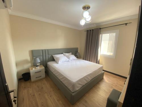 开罗شقة فندقية في منتجع اوشن بلو的一间卧室配有一张带白色床单的床和一扇窗户。