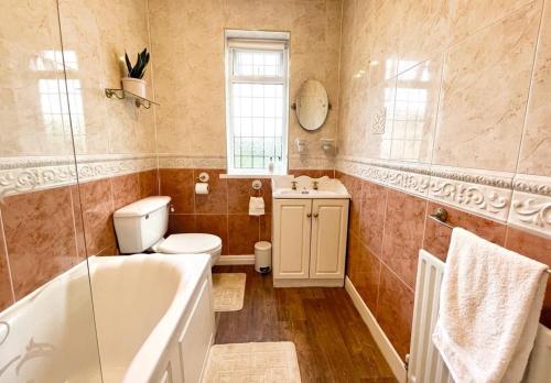 GreasbroughCosy Croft Cottage的带浴缸、卫生间和盥洗盆的浴室