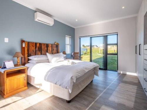 乔治The Halfway House @ Kingswood Golf Estate的卧室设有白色的床和大窗户