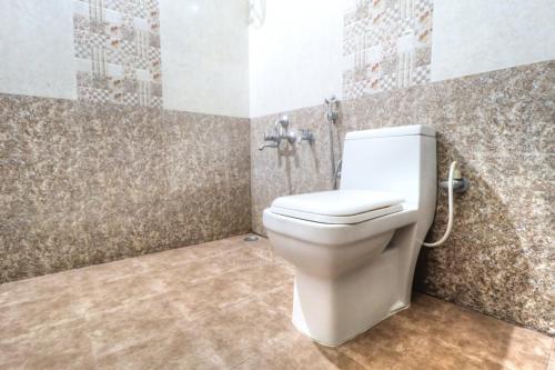 马迪凯里Coorg Avani Holiday Inn的浴室设有马赛克墙和卫生间。