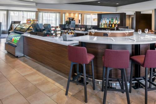 纽瓦克万怡纽瓦克自由国际机场酒店的一间酒吧,在旅馆房间设有红色椅子