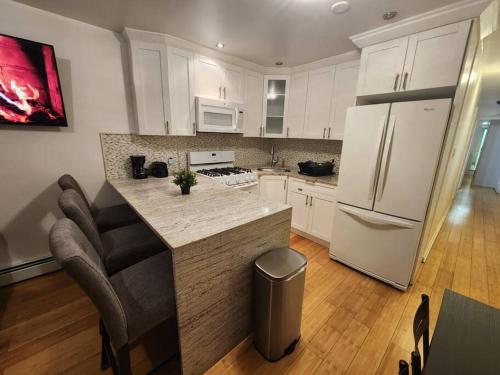 联城Cosy Modern Home Mins to NYC!的厨房配有白色橱柜和小岛