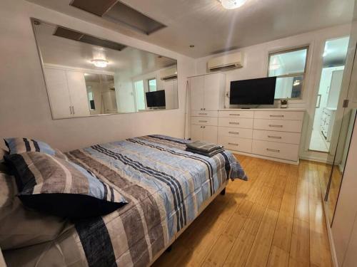 联城Cosy Modern Home Mins to NYC!的一间卧室配有一张床和一台平面电视